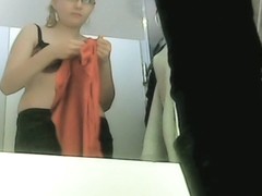Girl in black bra tries new cloths in the fitting room