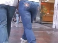 Girl in blue jeans walking with her boyfriend on the street