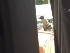 Girl in the window is sitting naked on the sofa