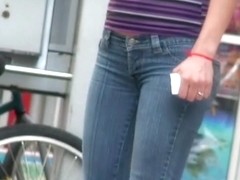 Young beautiful woman in blue jeans filmed on the public