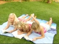 3 pretty blonde girls frolicking on the grass