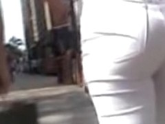 Girl in white trousers is on the street candid video 06m