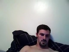 Handsome male is jerking in the guest room and shooting himself on computer webcam