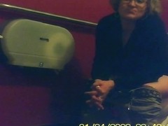 Mature unsuspecting female sitting on a toilet