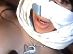 Masked Arabic lady plays with a big black dildo on tape