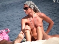 Cutie flaunts her perky tits in front of a nudist beach voyeur